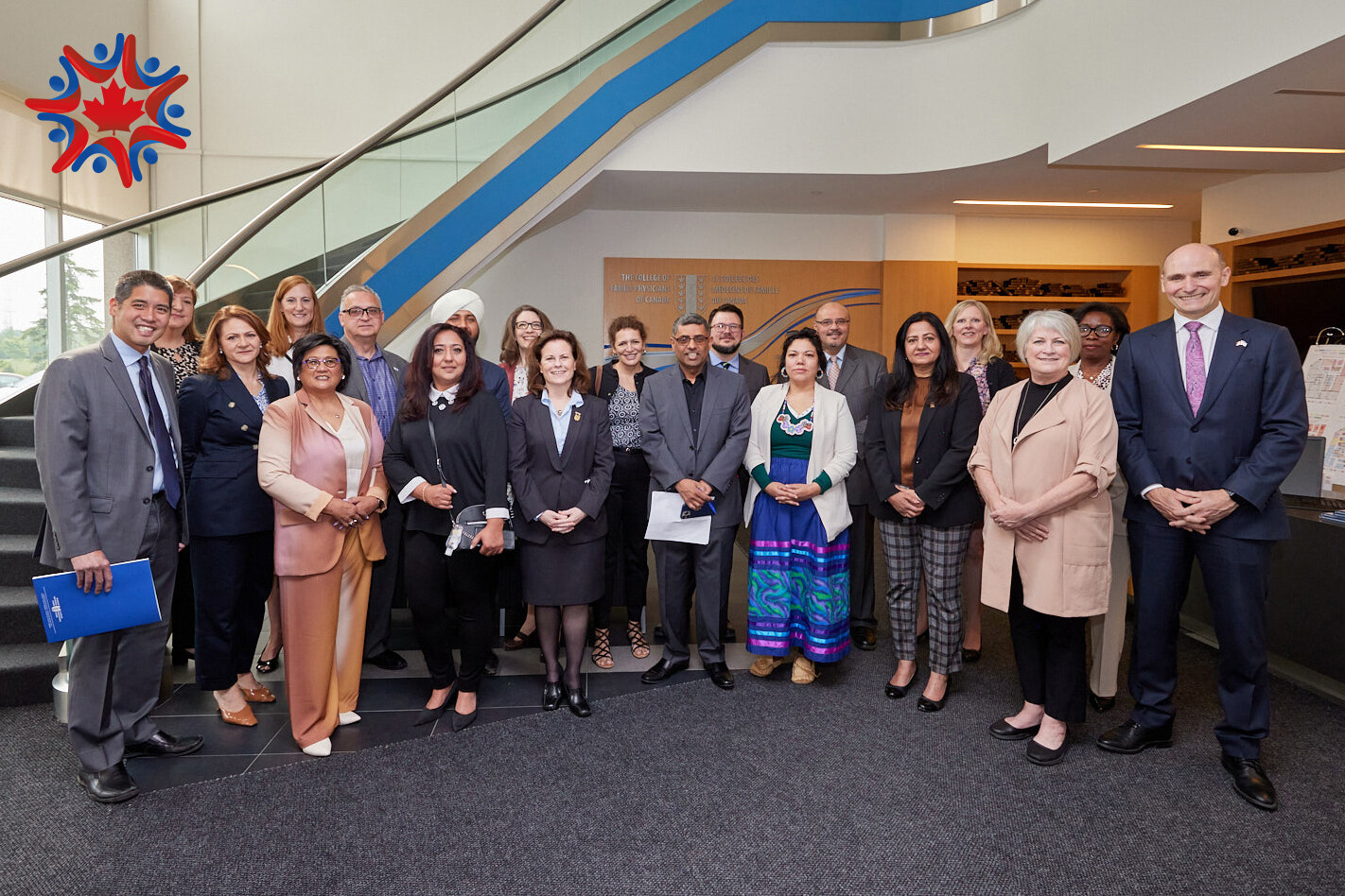 Group photo of Team Primary Care (TPC) grant members next to a staircase, with the TPC logo top right.